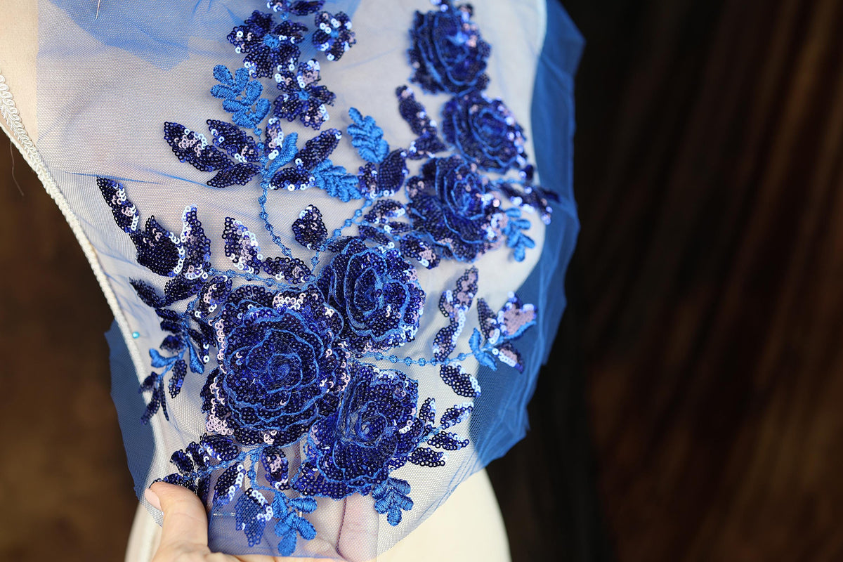 a woman wearing a blue dress with blue flowers on it