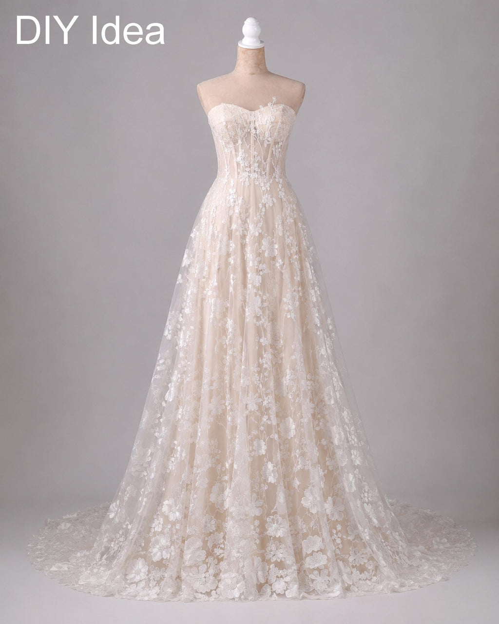 A beautiful, lace wedding dress with a long train and a sweetheart neckline, displayed on a mannequin.