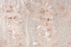 a close-up view of a fabric with a floral pattern, including various shades of pink and white flowers and leaves. The fabric appears to be made of a shiny, sequined material, giving it a sparkling and elegant appearance.