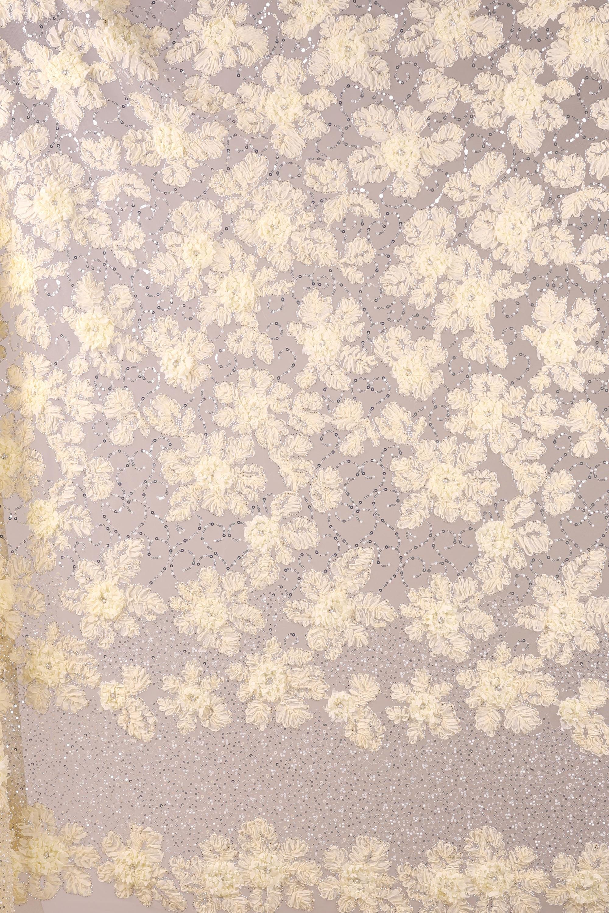 a close-up view of a fabric with a floral pattern, consisting of numerous small white flowers arranged in a repeating pattern. The fabric appears to be made of a sheer material, giving it a delicate and airy appearance. The image does not contain any text or other discernible objects, and the focus is solely on the floral pattern on the fabric.