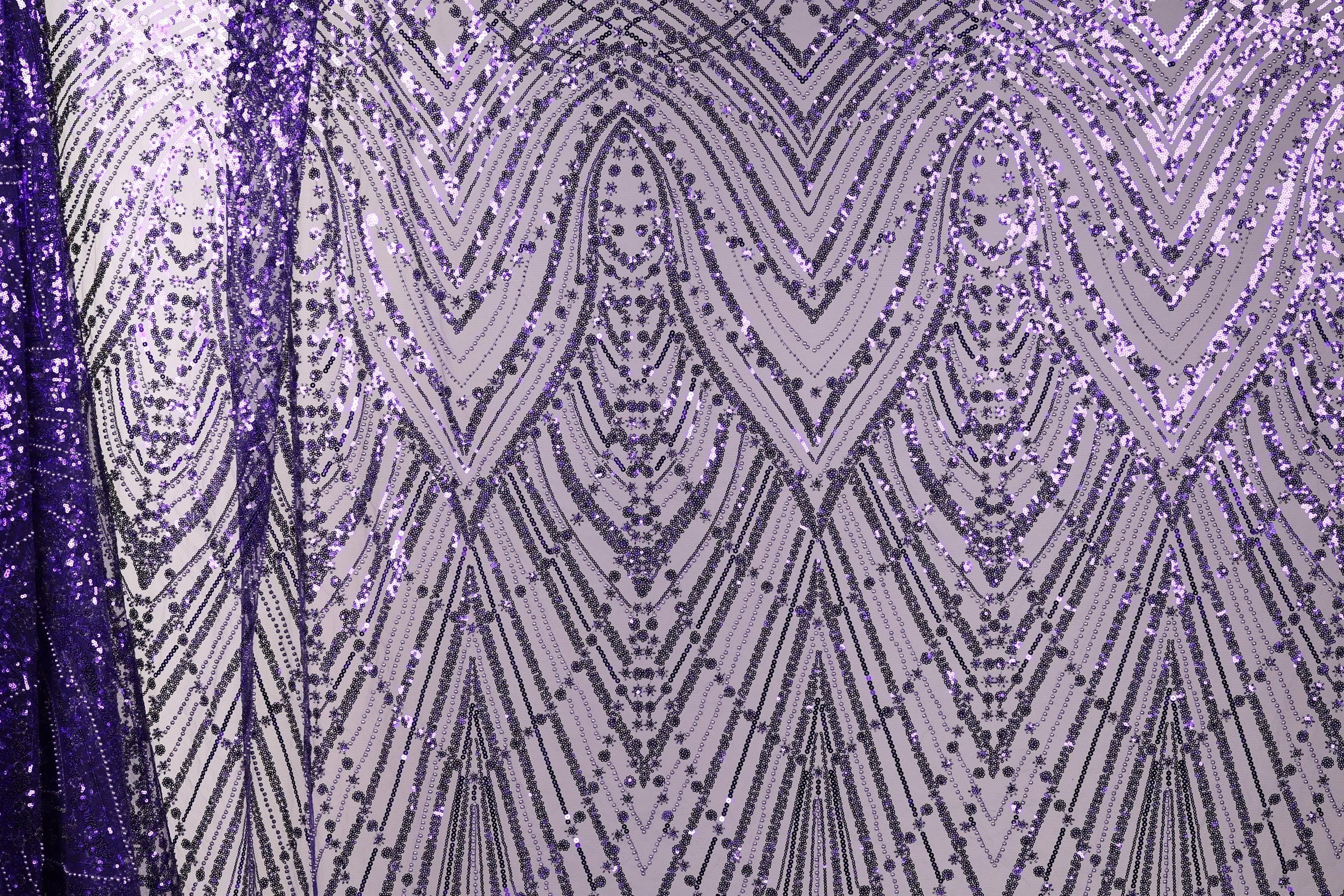a close-up view of a fabric with a purple and white pattern, consisting of a repeating diamond-shaped motif with a metallic sheen. The pattern is composed of numerous small dots and lines, creating a visually striking and intricate design.