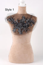 A mannequin with a decorative black lace or floral embellishment on its chest area.