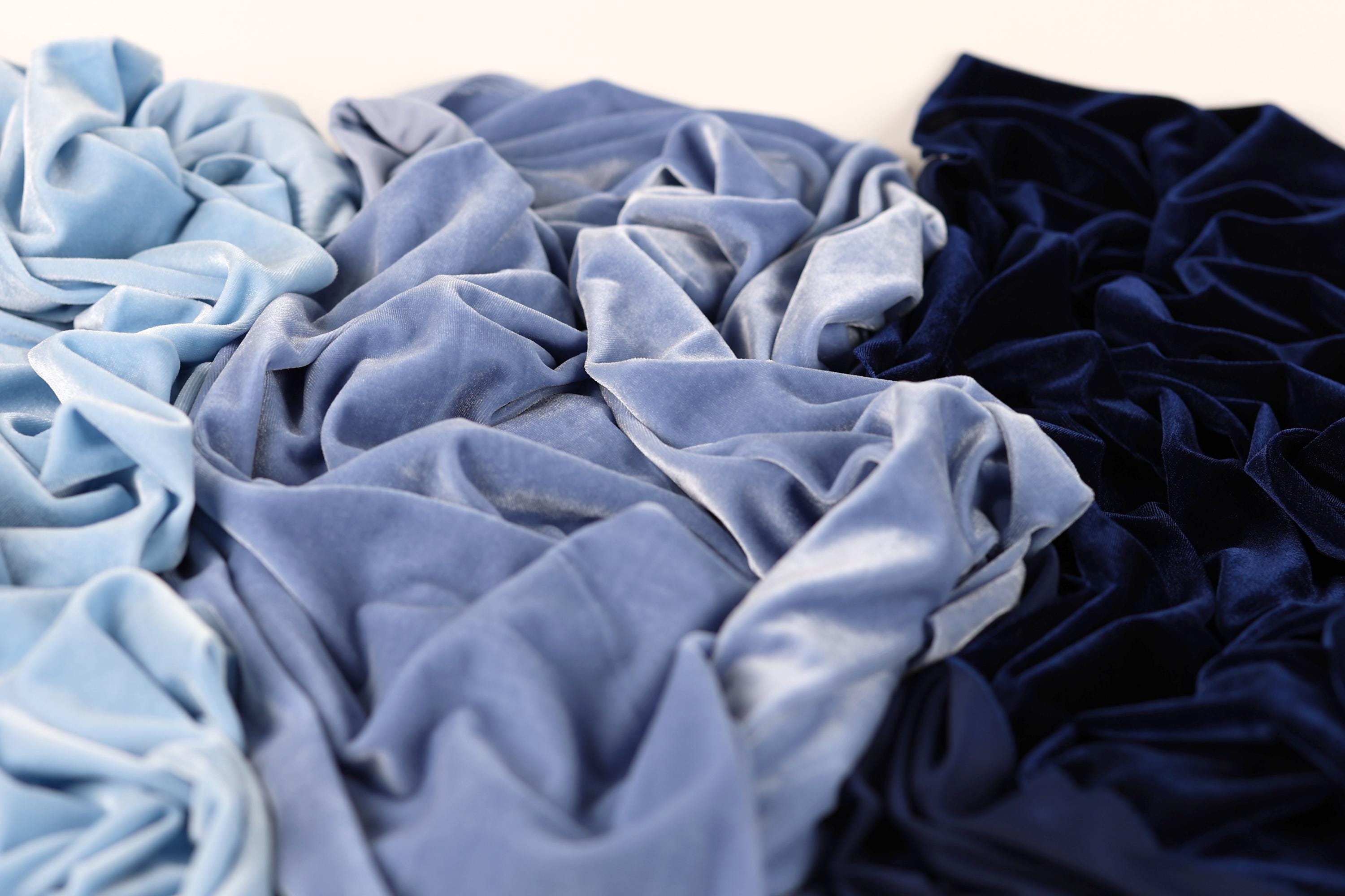 a close-up view of various textures, including blue and navy blue fabrics, with a focus on the folds and creases of the materials.