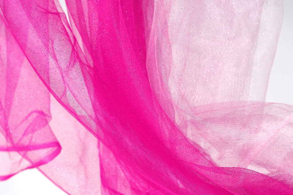 a close-up view of a pink and white fabric, with the pink fabric appearing more vibrant and the white fabric appearing more subdued.