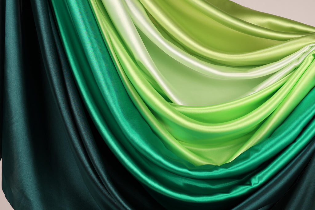a close-up view of a fabric with a gradient of green and black colors, creating a visually striking and vibrant pattern.