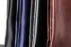 a close-up view of a collection of colorful satin fabric, with a focus on the vertical arrangement of the fabric.