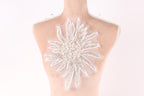 A mannequin bust with a large, intricate white flower-like design on the back.