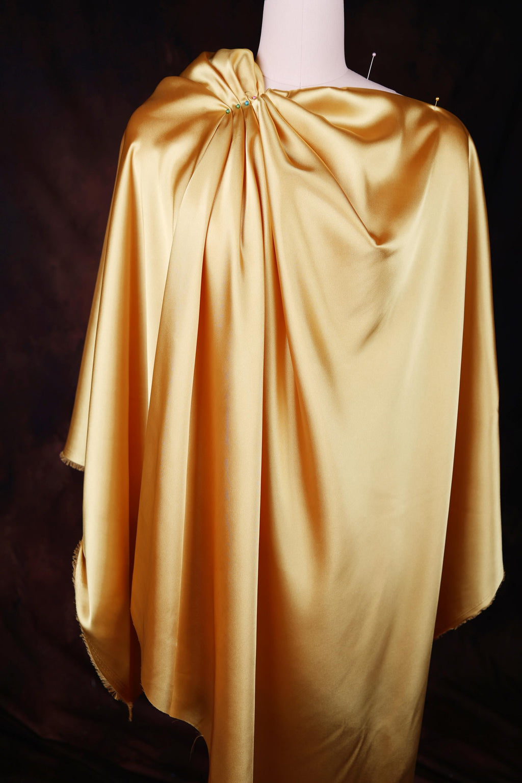 a mannequin wearing a yellow cape with a cross on it