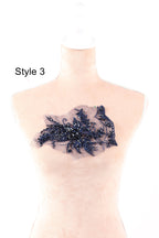 A mannequin wearing a dress with a decorative blue lace or beaded embellishment on the chest area.