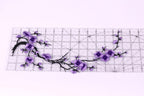 a clear ruler with a floral design of purple flowers and branches on it.