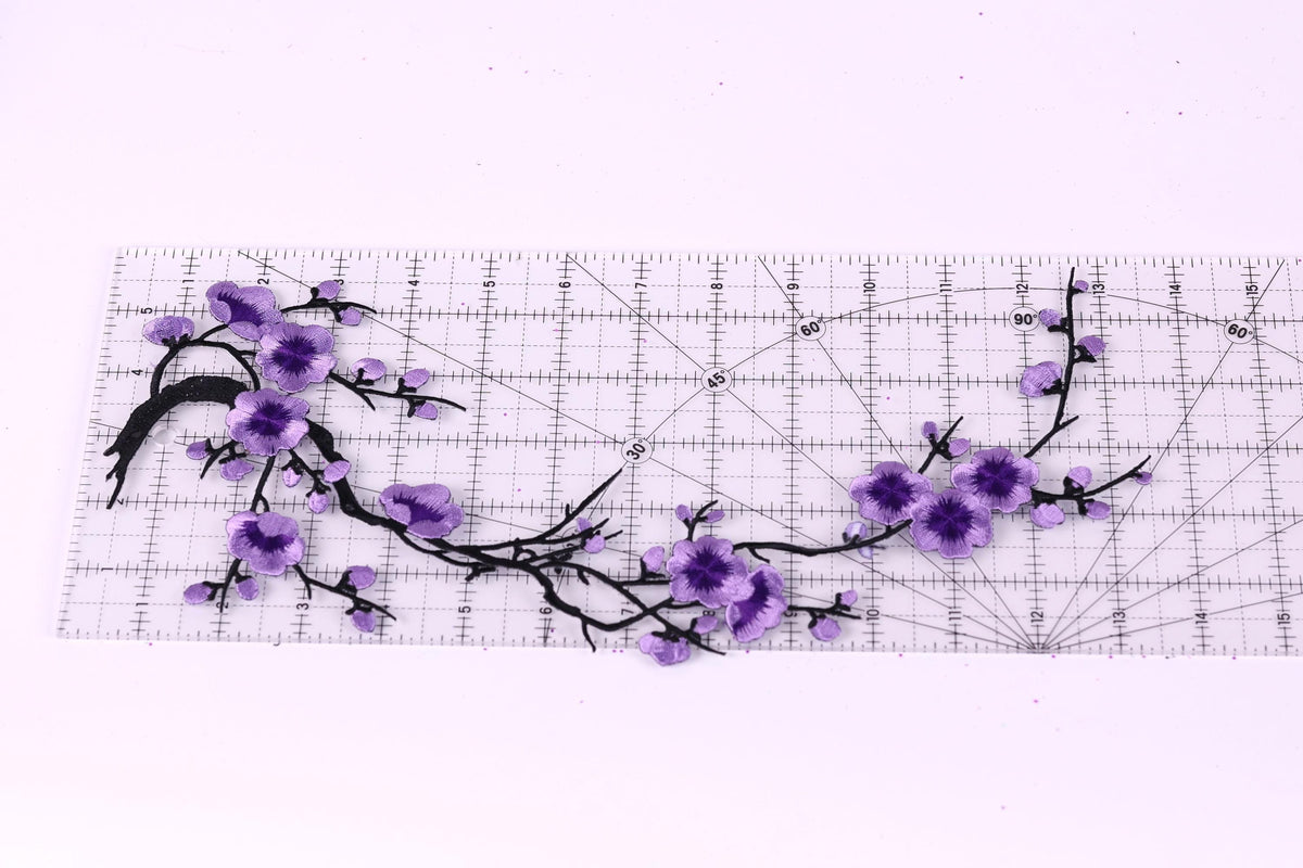 a clear ruler with a floral design of purple flowers and branches on it.