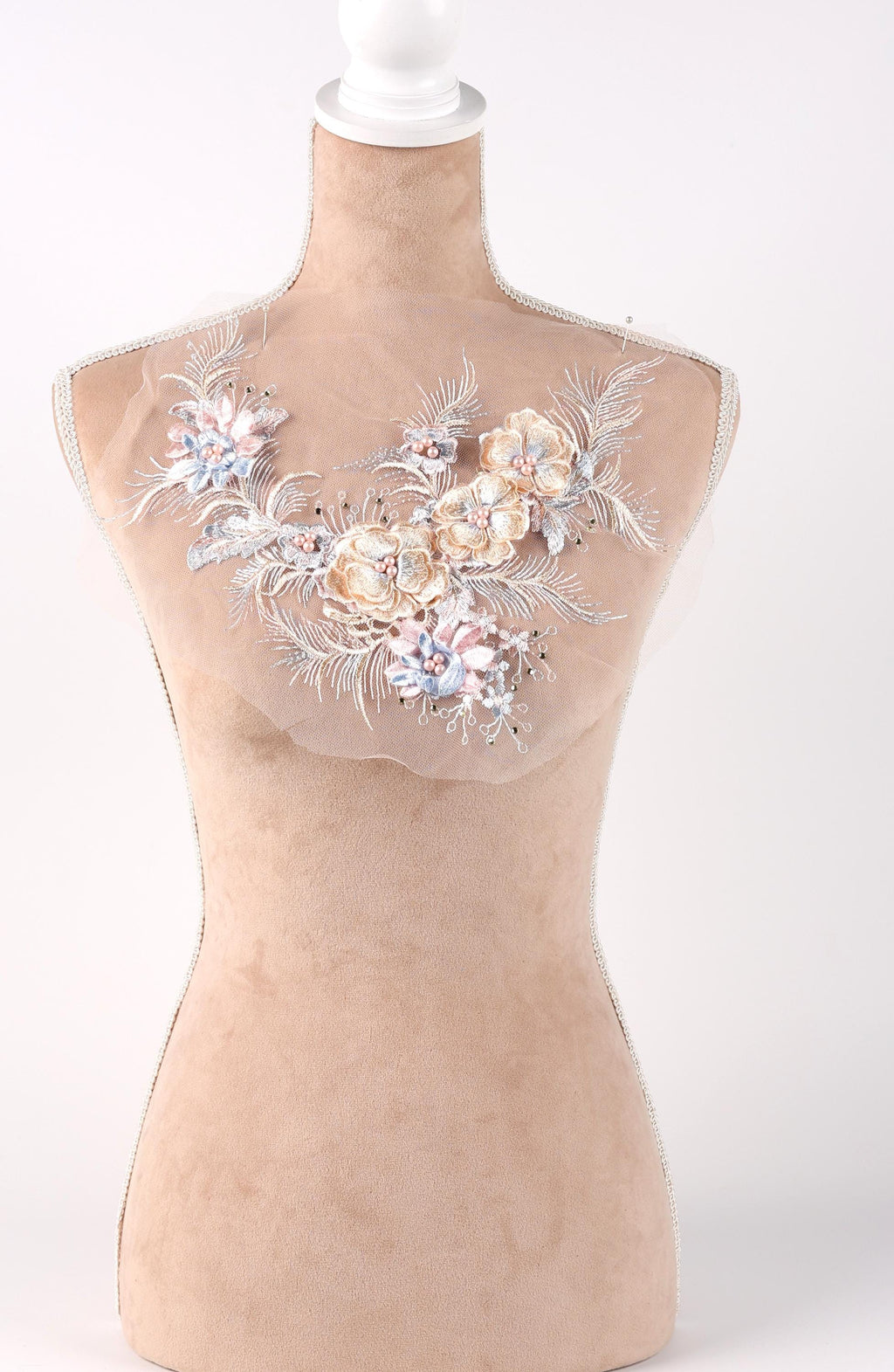 A mannequin with a beige body and a white head, wearing a necklace with a floral design.