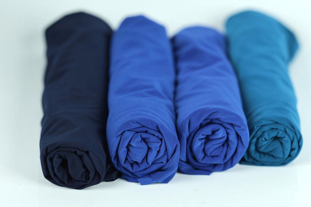 four rolled-up blue fabric pieces arranged in a row.