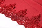 a close-up view of a red fabric with intricate, ornate red lace trim.