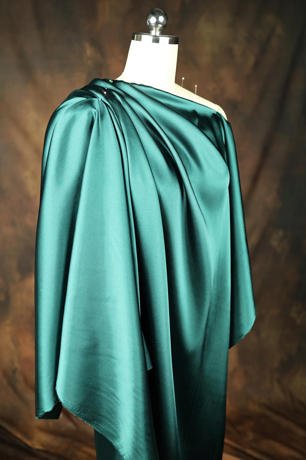 a dress on a mannequin with a green cape
