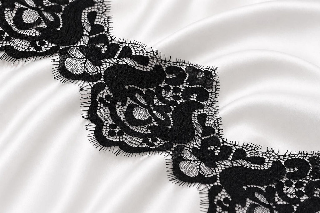 a close-up view of a delicate black lace pattern on a white fabric surface.
