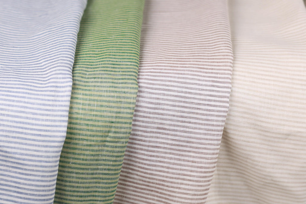 a close-up view of four fabric swatches, each with a different color and pattern of horizontal stripes.