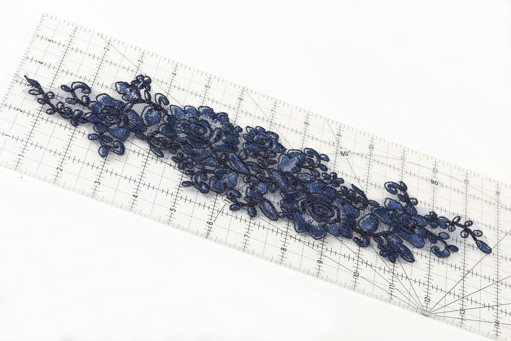 a close-up view of a blue floral embroidery on a ruler, showcasing intricate details and patterns.