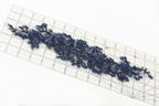 a close-up view of a blue floral embroidery on a ruler, showcasing intricate details and patterns.