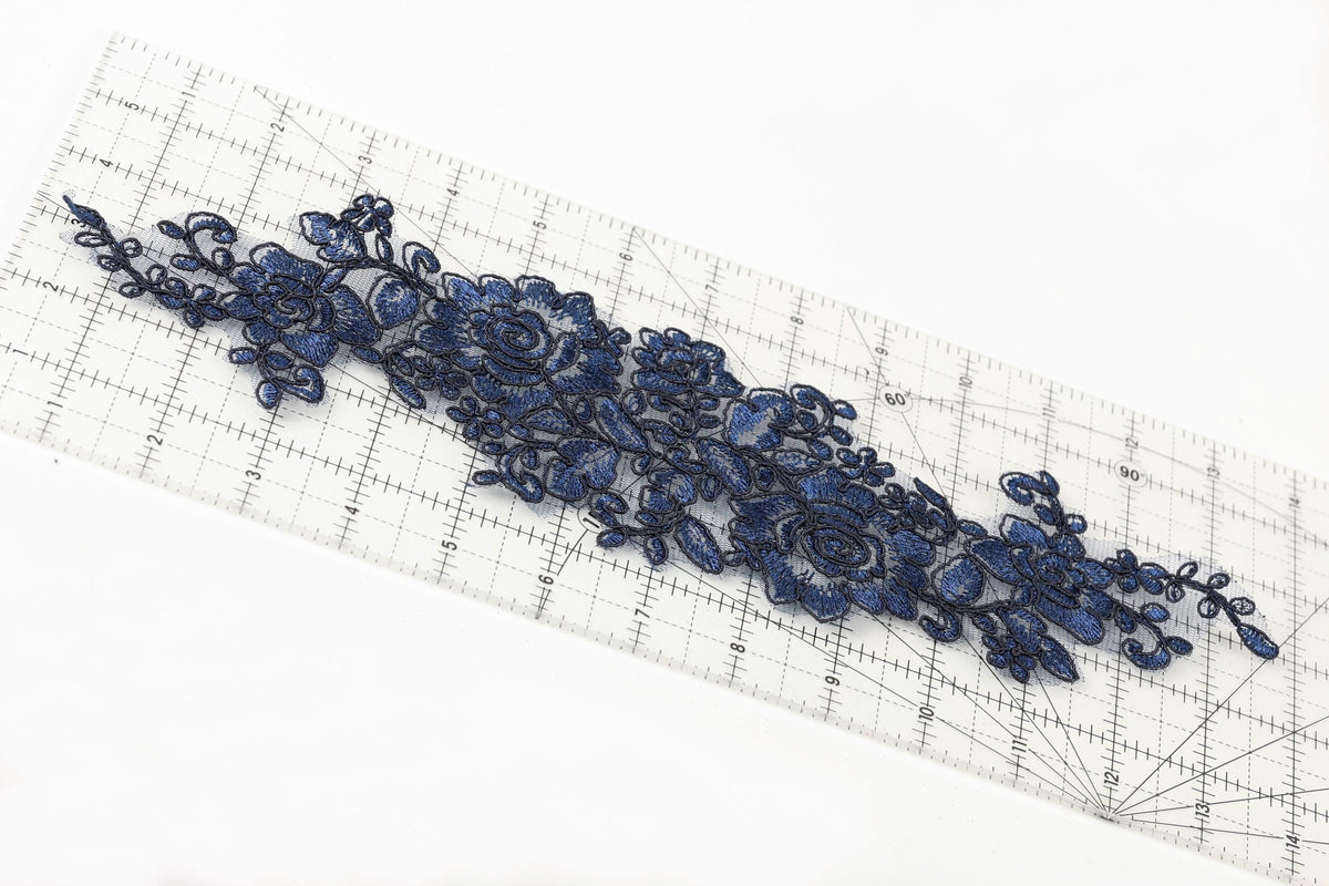 a close-up view of a blue floral embroidery on a ruler, showcasing intricate details and patterns.