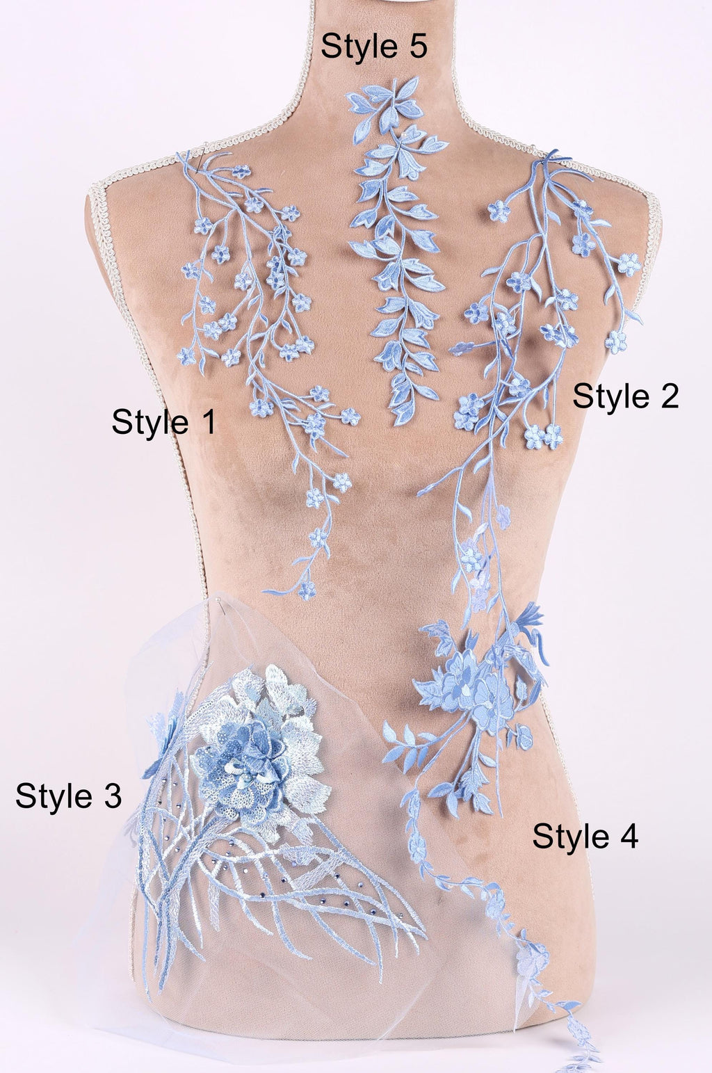A mannequin with various blue floral and leaf-like designs attached to its torso, each with a different style number.