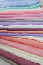 a pile of different colored fabric on a table