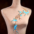 A mannequin with a floral design on its chest, featuring blue flowers and branches.