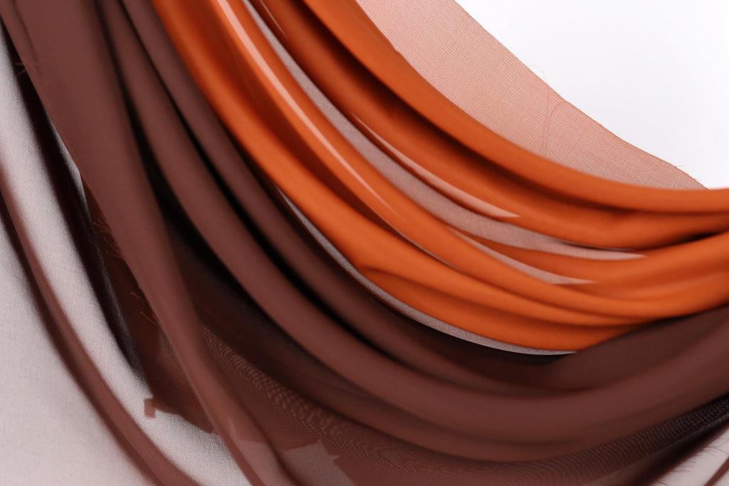 a close-up view of a fabric with a mix of brown and orange colors, creating a visually appealing and textured appearance.