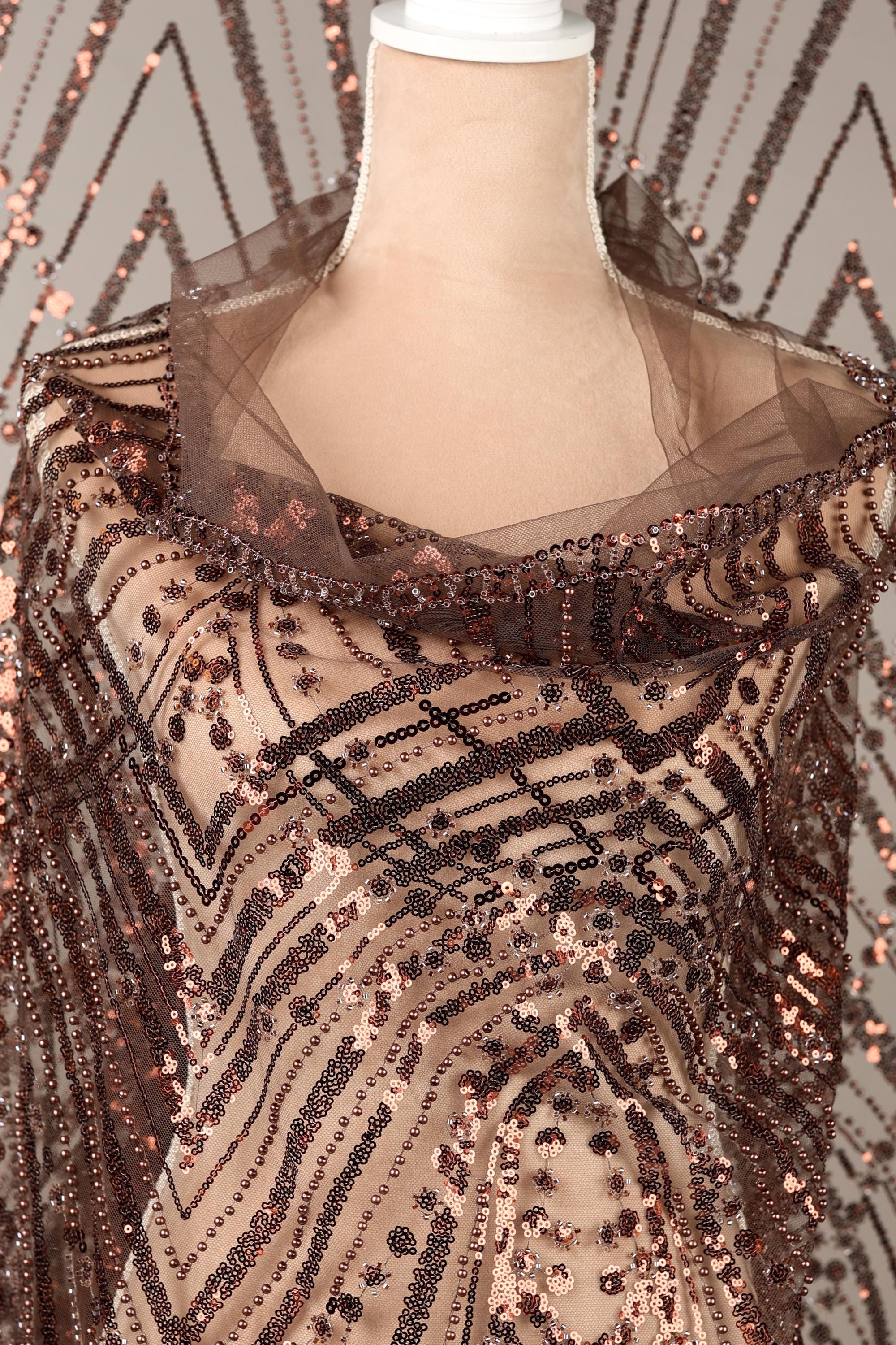 a mannequin wearing a brown sequin dress with a sheer overlay.