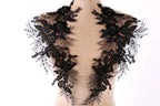 A mannequin wearing a black lace collar with intricate floral and leaf designs.