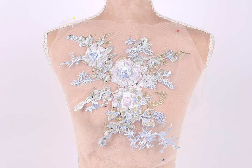 A mannequin torso with a delicate floral embroidered patch on the back.