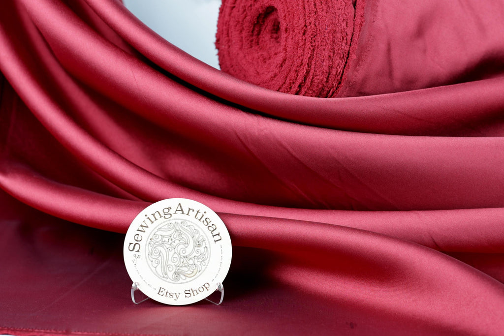 a red fabric with a white circular sign in the foreground, which reads "Sewing Artisan Ety Shop".