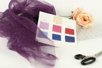 a variety of fabric swatches, a pair of scissors, and a rose, all arranged on a white background.