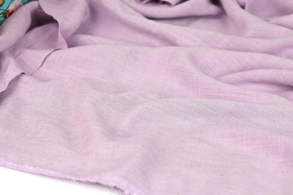A close-up view of a soft, light purple fabric, possibly a piece of clothing or textile.