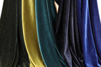 a collection of colorful velvet fabric, with various shades of green, blue, and black. The fabric appears to be made of a shiny, glittery material, giving it a vibrant and eye-catching appearance.
