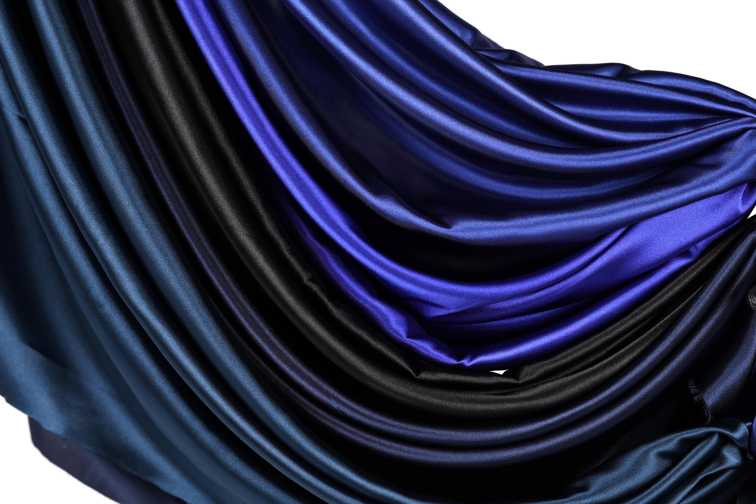 a close-up view of a fabric with a gradient of blue and black colors, creating a visually striking and textured appearance.