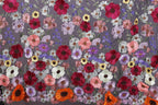 a vibrant and colorful floral pattern, with a variety of flowers in shades of red, pink, white, and purple. The flowers are intricately embroidered or sewn onto a fabric, creating a visually striking and detailed design.