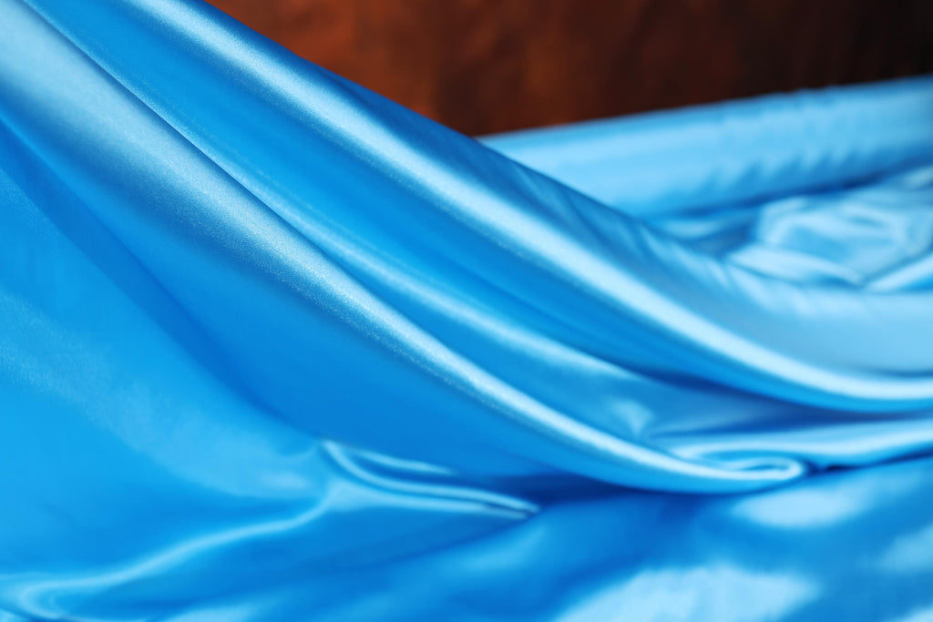 a close up of a blue cloth on a bed