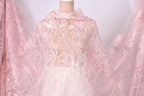 A mannequin wearing a pink lace dress with a floral pattern.
