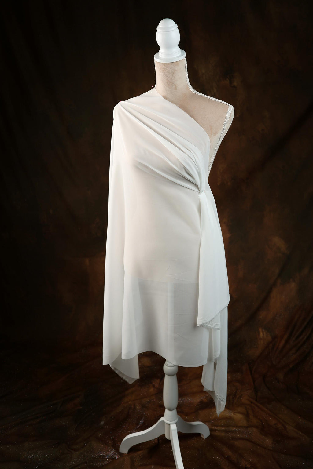 a white dress on a mannequin on a black background