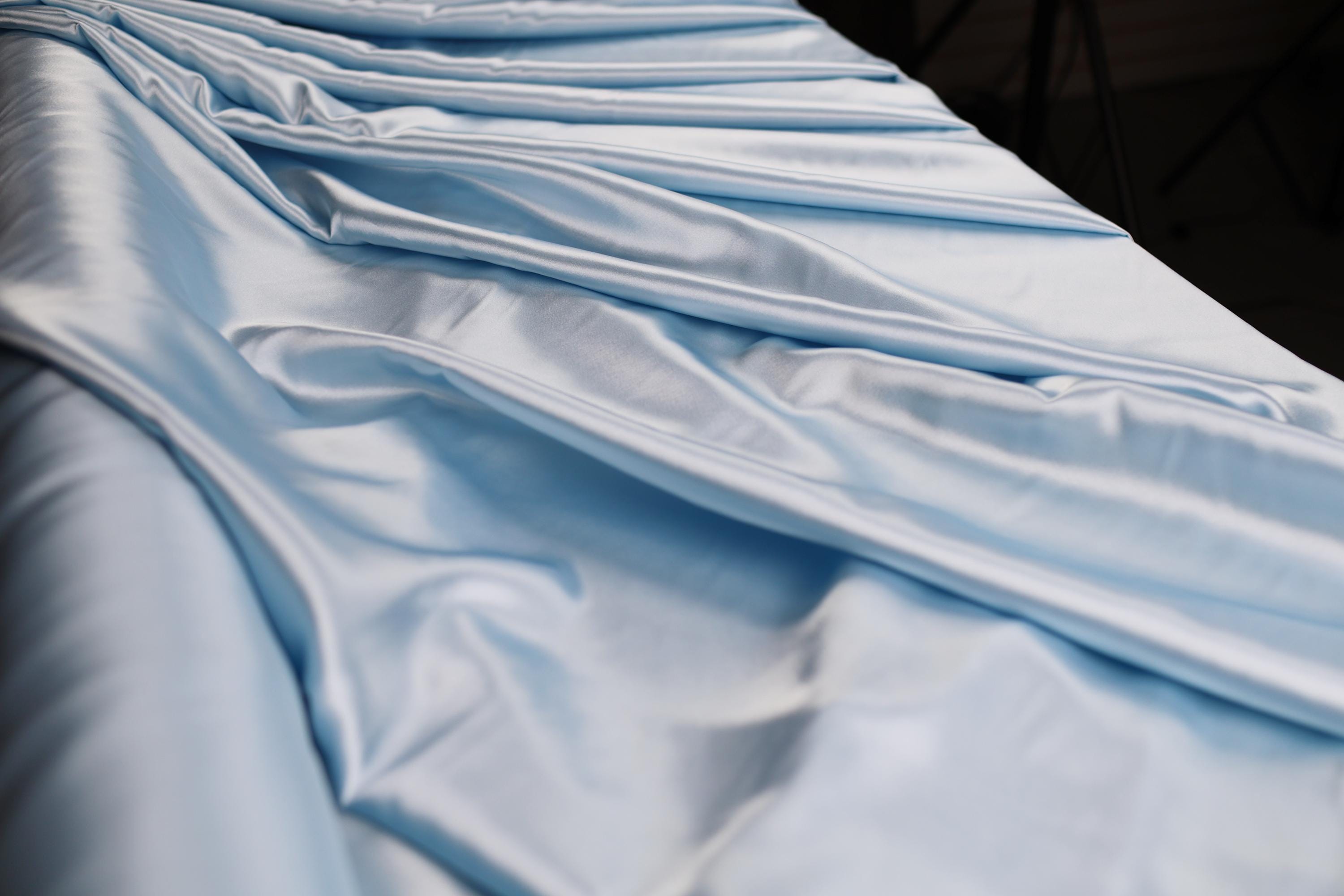 a close up of a bed with blue sheets