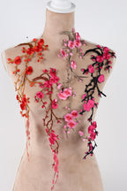a mannequin with a beige fabric body adorned with a floral design in shades of pink and red.