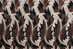 a repeating pattern of brown and black floral designs on a beige background.