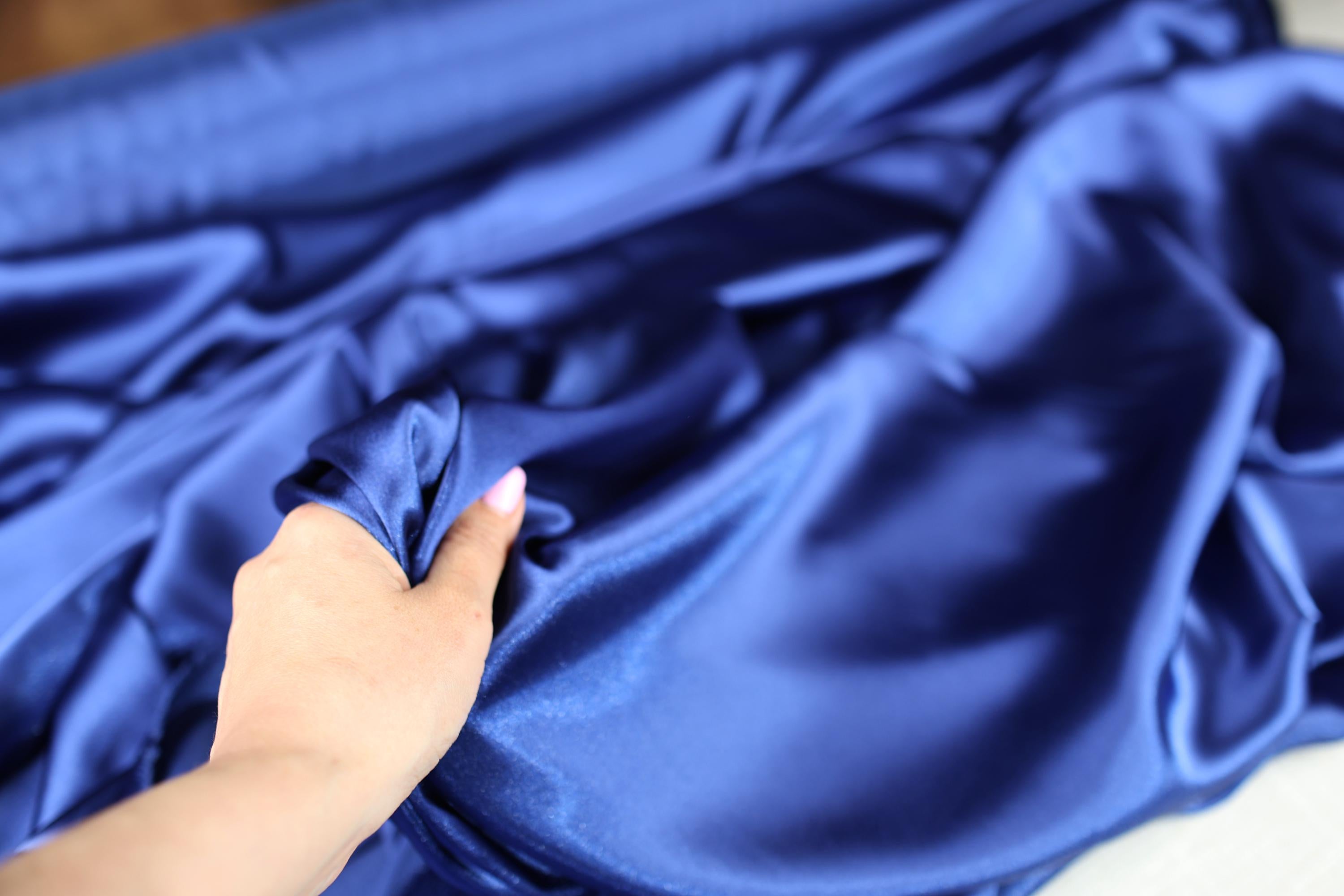 a person holding a piece of blue cloth