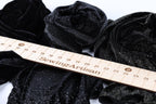a close-up view of a sewing ruler with the word "SewingArtisan" printed on it, surrounded by various black fabric pieces.