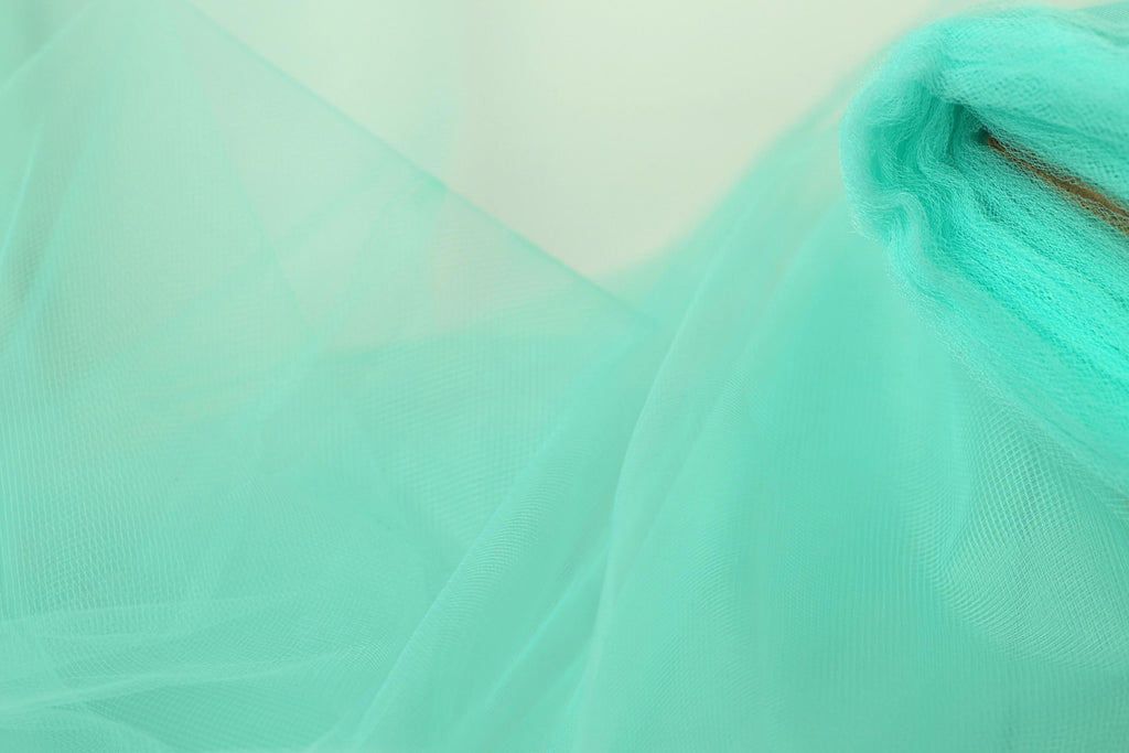 A close-up view of a light blue, sheer fabric, possibly tulle, with a subtle texture.