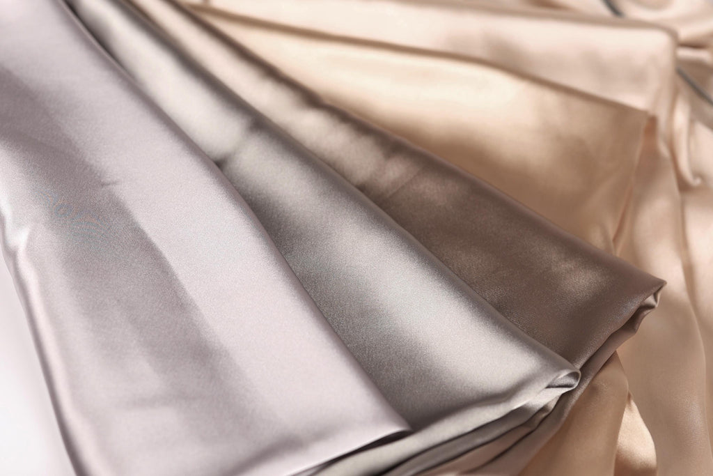 a close-up view of a fabric with a mix of light and dark colors, including shades of gray and brown.