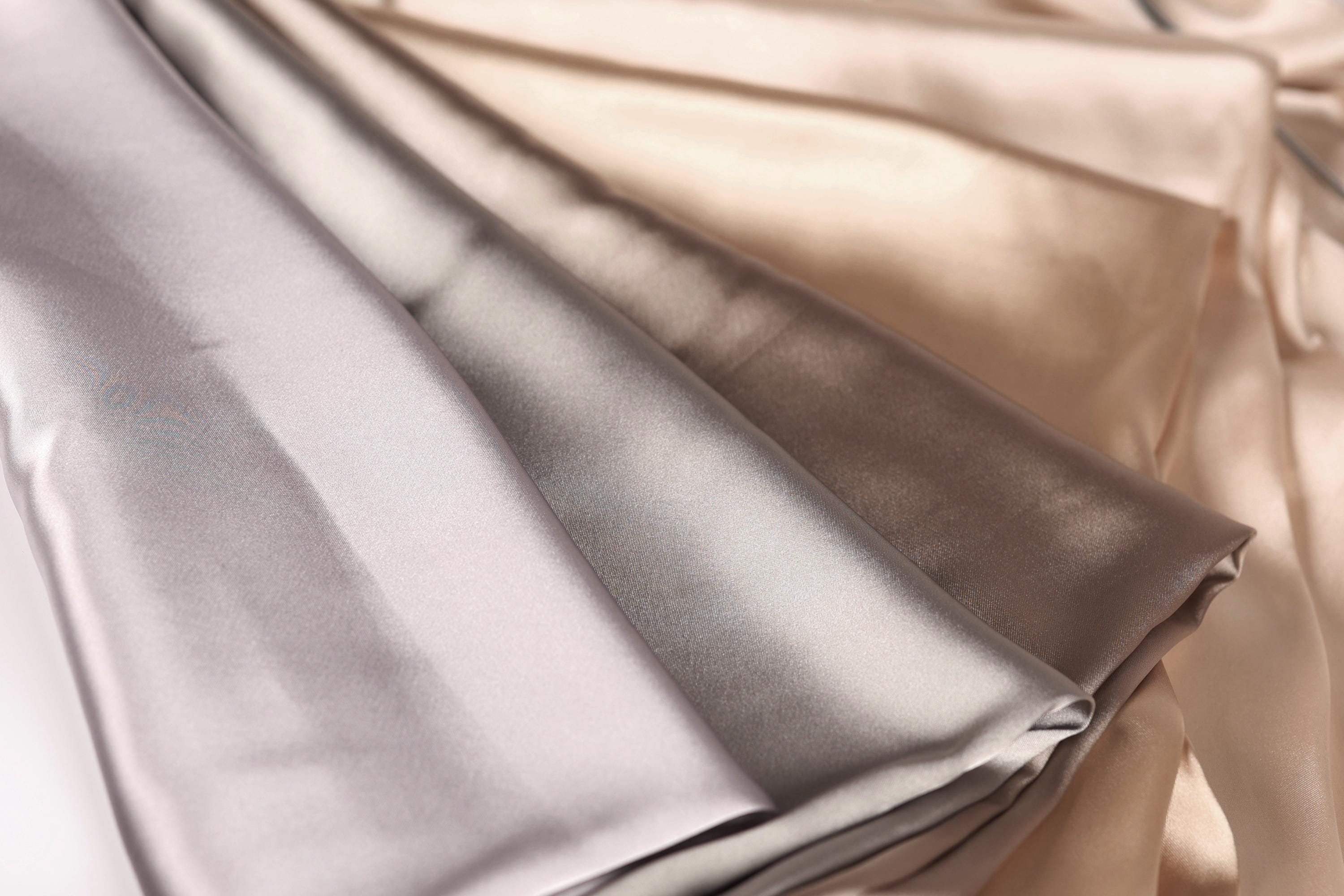 a close-up view of a fabric with a mix of light and dark colors, including shades of gray and brown.