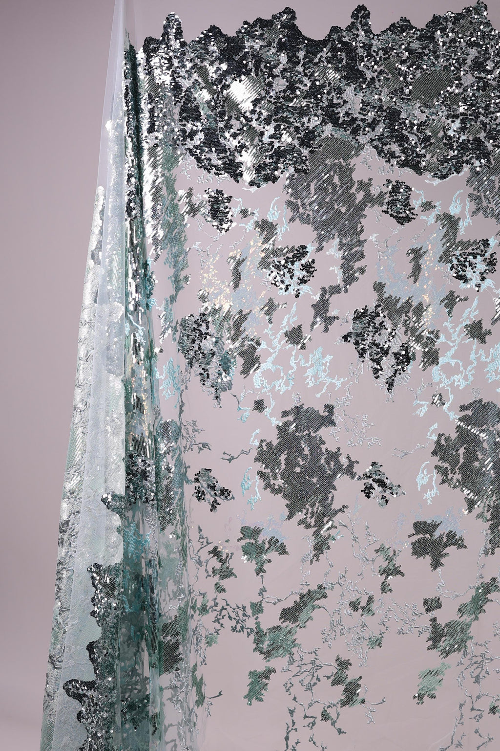 The image is a collage of various textures and patterns, including a metallic, textured surface with a mix of black, gray, and white elements.