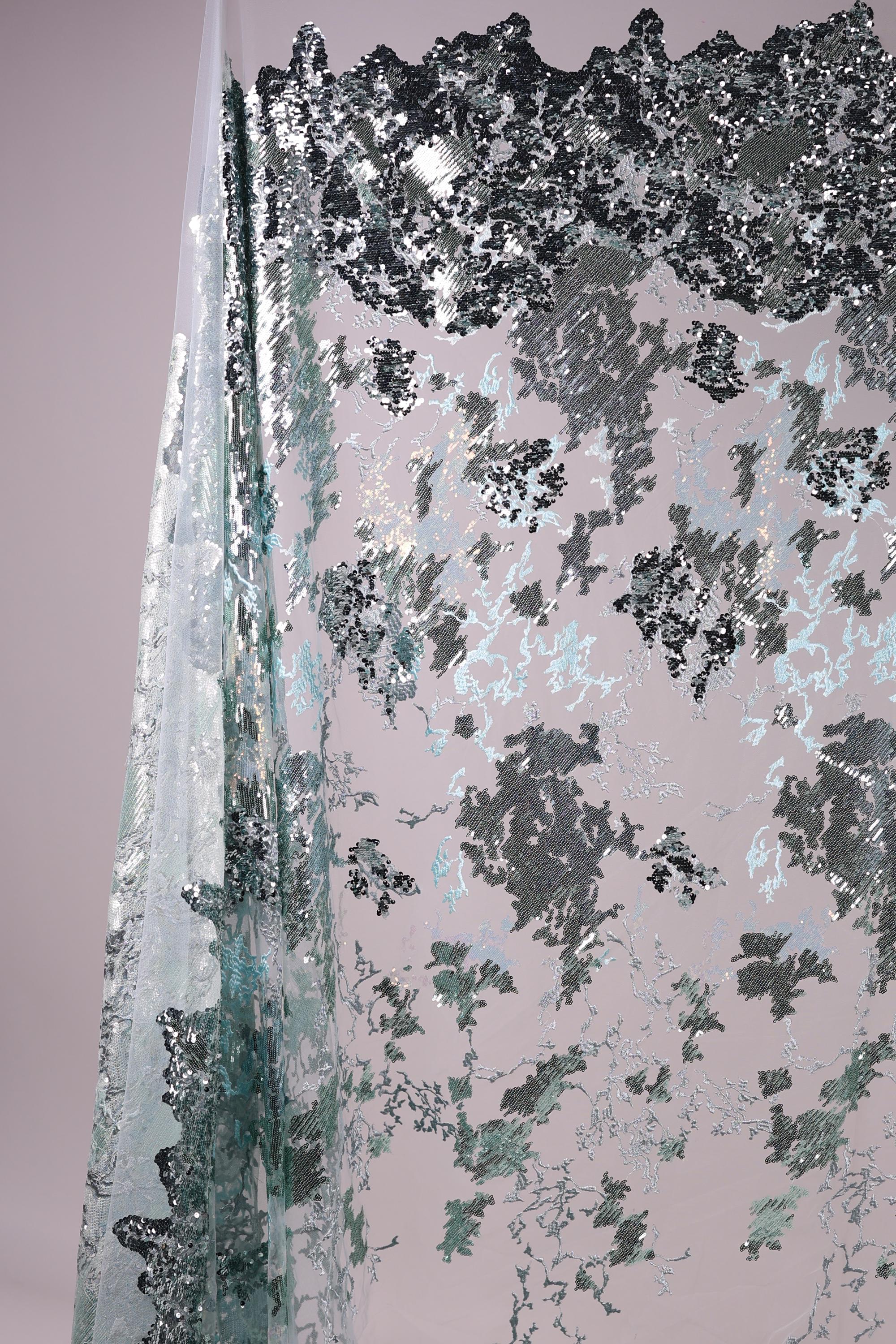 The image is a collage of various textures and patterns, including a metallic, textured surface with a mix of black, gray, and white elements.